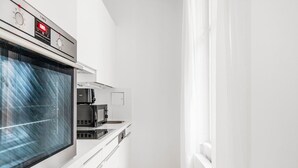 A modern kitchen with a built-in oven, microwave, and coffee maker. - Blueground | Neubau, view, nr MuseumsQuartier (Vienna)