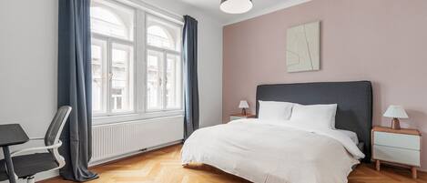 Une chambre à coucher moderne, dotée d’un grand lit, d’un bureau et d’une chaise.