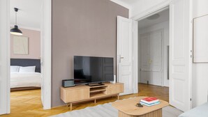 A modern living room with a flat-screen TV on a wooden stand, a sofa, and a coffee table. - Blueground | Neubau, view, nr MuseumsQuartier (Vienna)