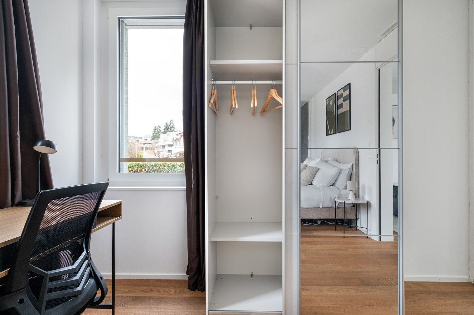 Une chambre moderne équipée d’un bureau, d’une chaise, d’une armoire et d’un lit.
