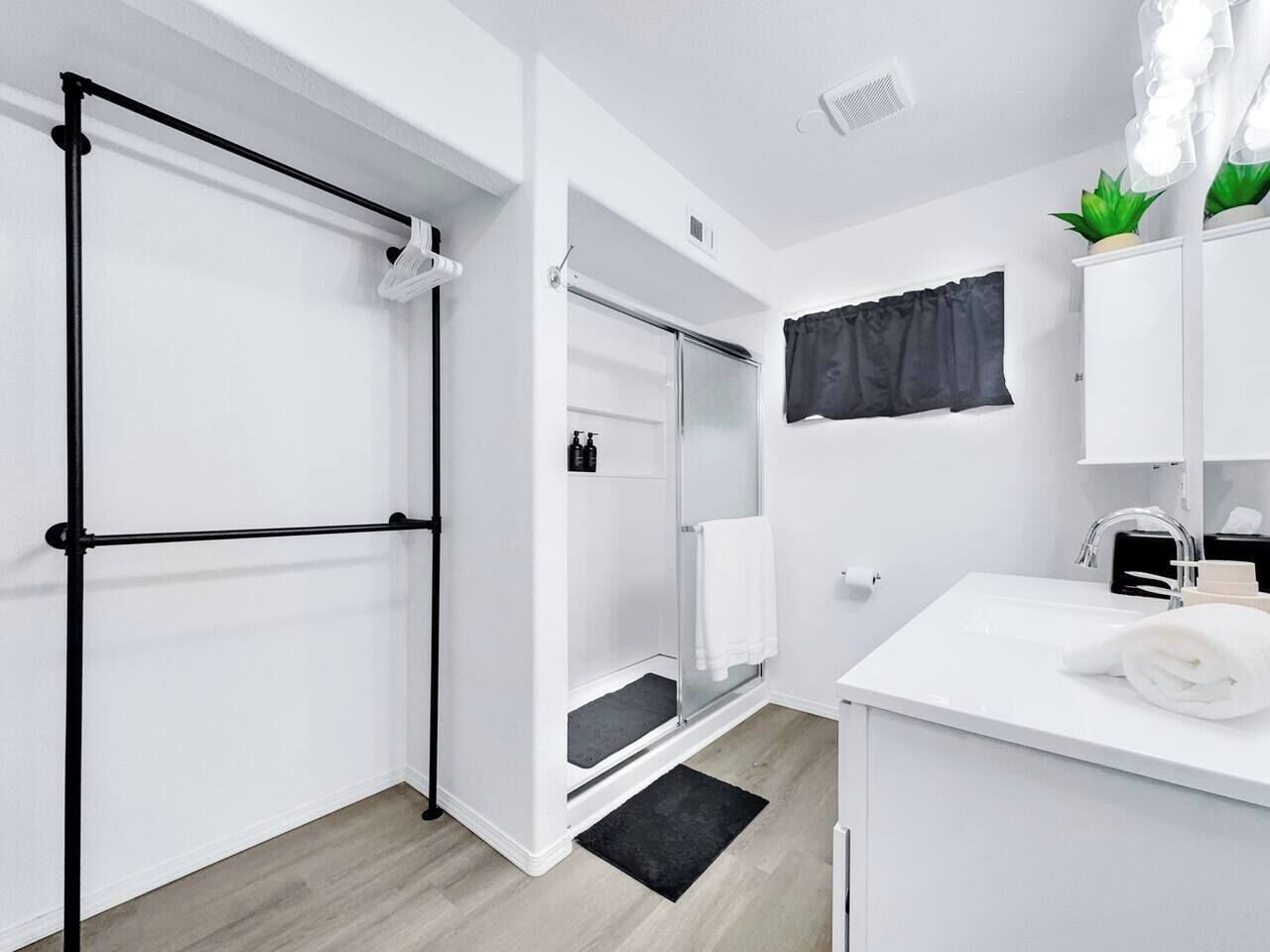 A modern bathroom with a shower, a toilet, and a sink.