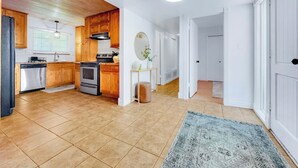 A spacious kitchen with wooden cabinets, a dishwasher, and a stove. - Revolta Fairway Retreat (Mesa)