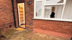 Une maison en briques avec un petit porche, une porte et une fenêtre.