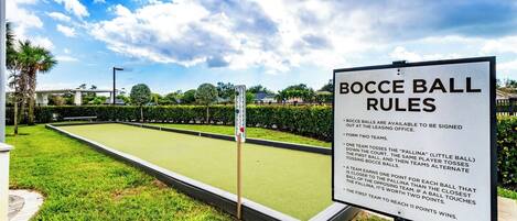 A bocce ball court with a sign detailing the rules.