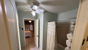 A bathroom with a shower, a bathtub, and a ceiling fan. - Charming 3-bedroom house 20 min. To downtown Austin, 20 min. To Dripping Springs (Austin)