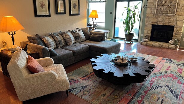 A living room with a sofa, armchair, and coffee table, a fireplace, and framed artwork on the wall. - Charming 3-bedroom house 20 min. To downtown Austin, 20 min. To Dripping Springs (Austin)