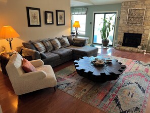 A living room with a sofa, armchair, and coffee table, a fireplace, and framed artwork on the wall. - Charming 3-bedroom house 20 min. To downtown Austin, 20 min. To Dripping Springs (Austin)