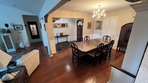 A dining area with a large wooden table and chairs, a chandelier, and a fireplace. - Charming 3-bedroom house 20 min. To downtown Austin, 20 min. To Dripping Springs (Austin)