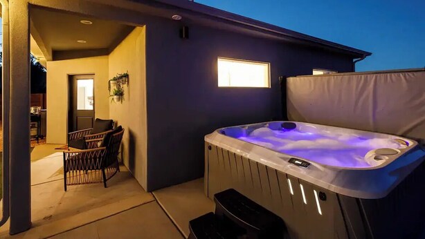 An outdoor hot tub area with a chair and a covered seating area. - Kanab Retreat | Hot Tub, EV Charger, Near Zion (Kanab)