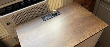 A kitchen with a wooden countertop, a Hisense appliance, and a brick wall.