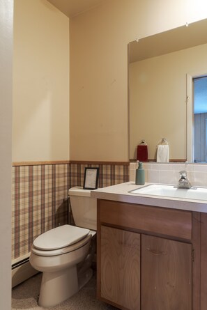 Un bagno con il water, un lavandino e uno specchio.