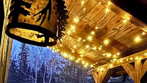 A hot tub under a wooden structure with string lights. - Secluded Cabin near Lake Vermillion, Sleeps 10, with Hot Tub, and Pet Friendly (Angora)