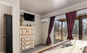 A bedroom with a bed, a wooden dresser, a flat-screen TV, and a window with plaid curtains. - 2-bedroom and more townhome in the heart of Wintergreen (Wintergreen Resort)