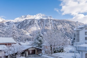 Eine Berglandschaft mit schneebedeckten Bäumen und einem Gebäude mit Garage.