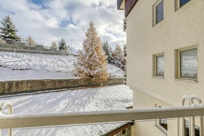 A snow-covered balcony with a view of a snow-laden slope and a building with a balcony railing. - Gran Roc 23 with Parking near Slopes, Sestriere, Italy (Sestriere)