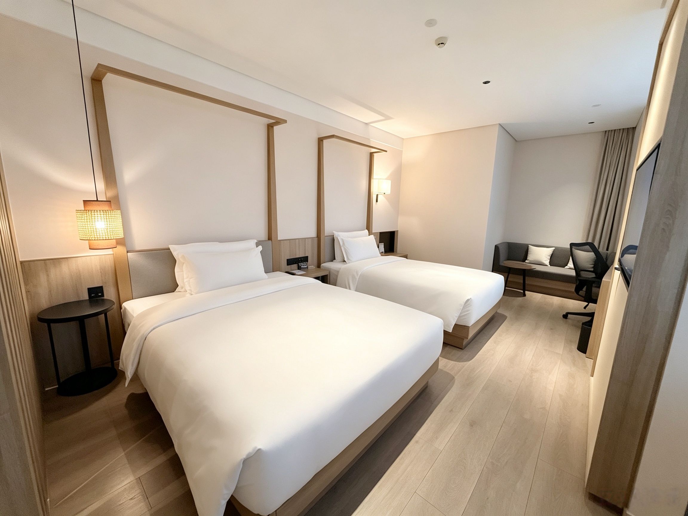A hotel room with two beds, a desk, a chair, and a mirror.