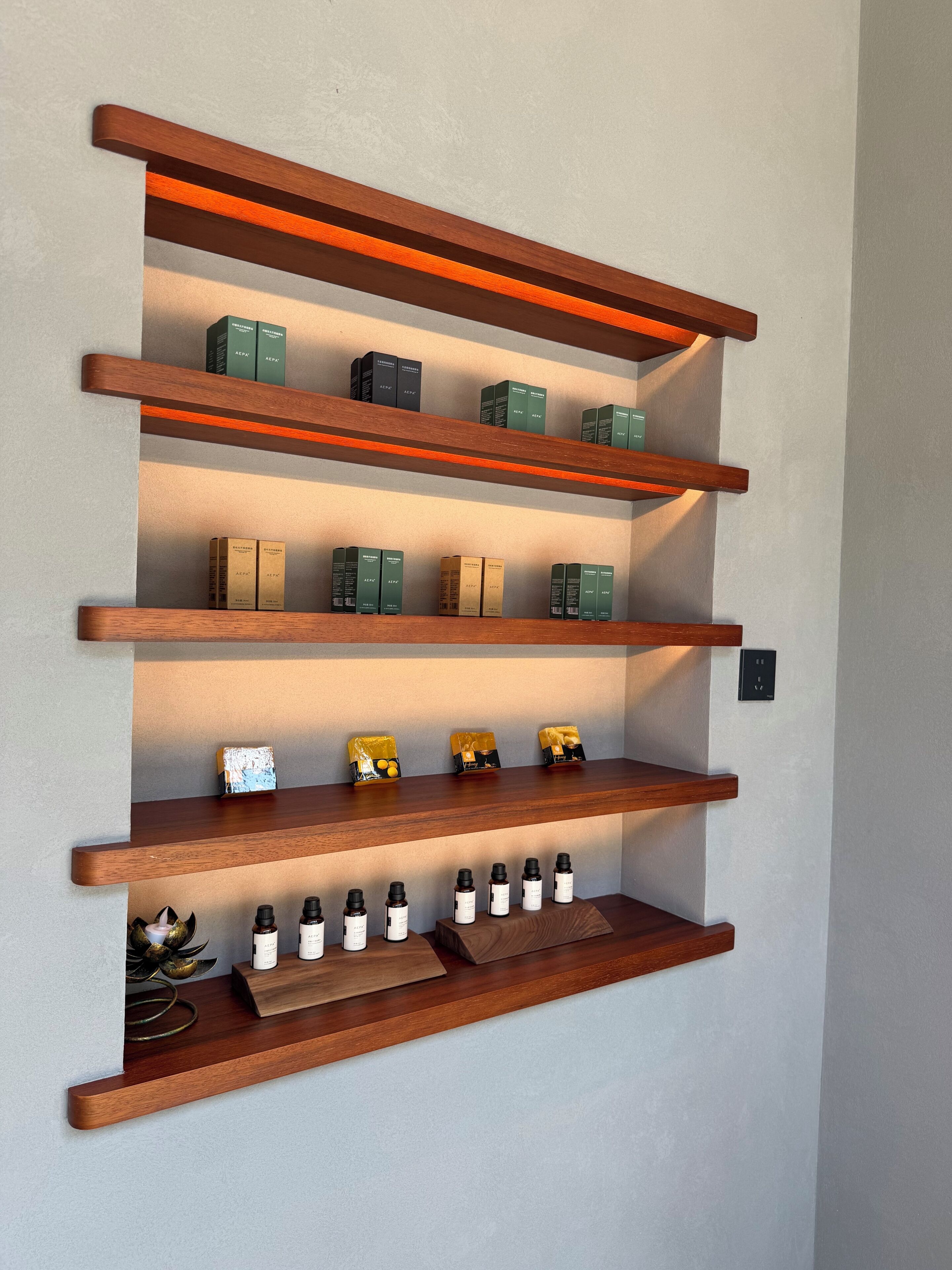 A wall-mounted wooden shelf unit with multiple compartments holding various items.
