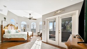 Ein Schlafzimmer mit einem Bett, einem Schreibtisch, einem Stuhl und einem großen Fenster.