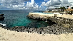 Un resort costero con vistas claras al océano, una costa rocosa y una zona de piscina.