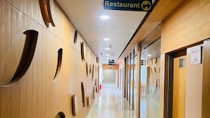 Un pasillo de hotel con señales que indican la sala de banquetes, los baños y el restaurante.