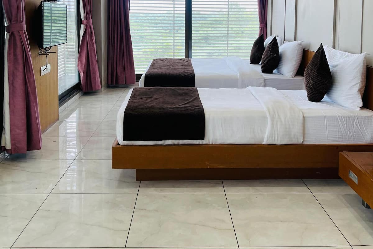 A modern hotel room with a large bed, a ceiling fan, and a TV on a wooden cabinet.