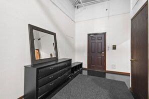Un pasillo con un aparador de madera oscura, un espejo grande y una puerta de madera oscura.
