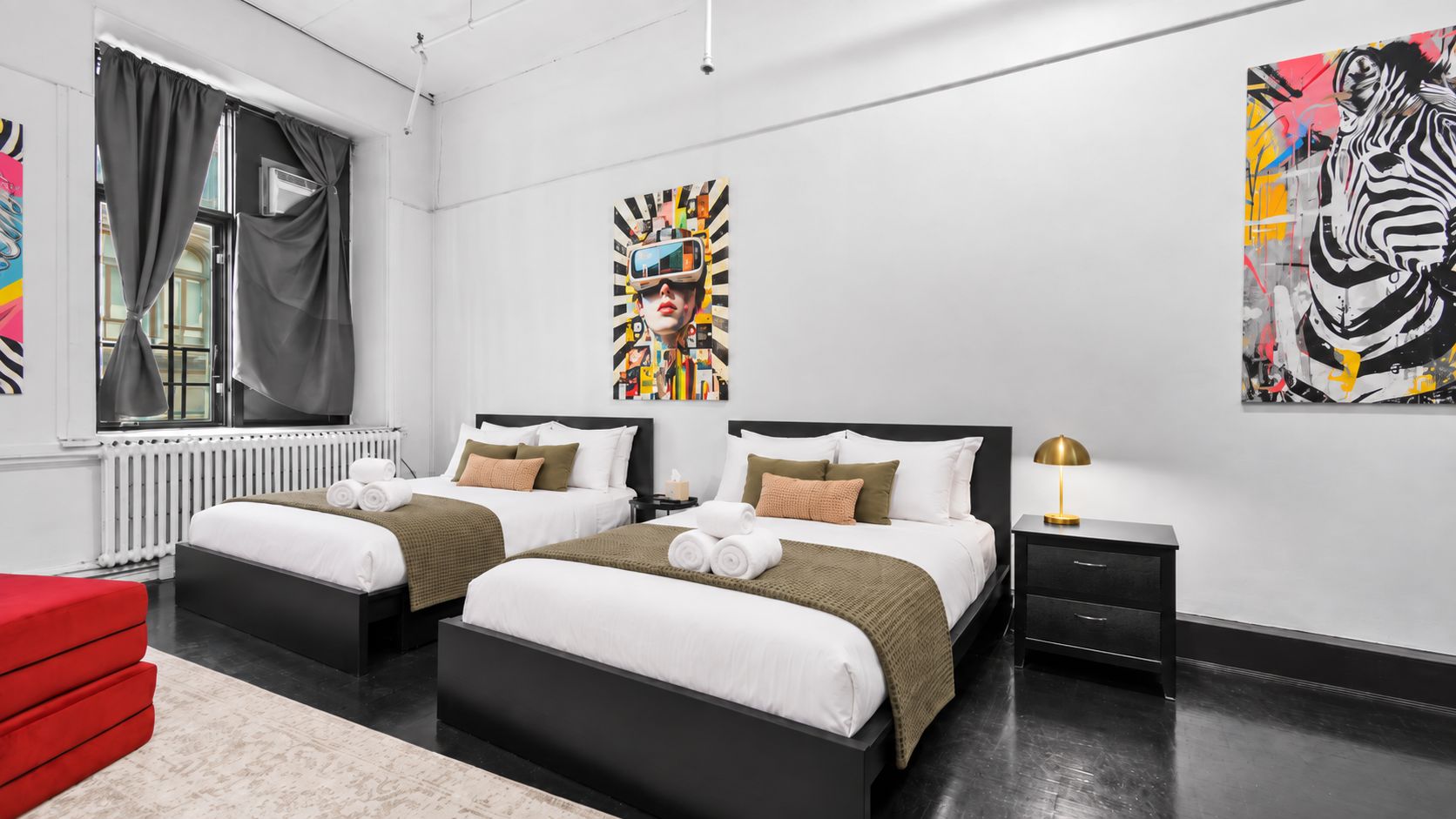 A modern hotel room with two beds, a red sofa, and artwork on the walls.