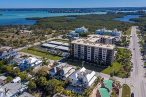 An aerial view of a coastal residential area with buildings, roads, and a marina. - Big Kahuna Steps to Beach w/ Waterslide Pool & Spa (Sarasota)
