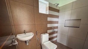 Un bagno moderno con lavandino, wc e doccia.