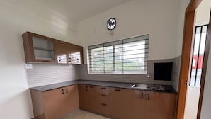 Una cucina con una finestra, mobili e una ventola.