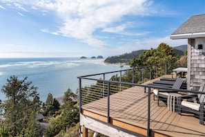 A deck with outdoor seating overlooking a coastal view. - Magnificent Oceanview Retreat w/ Hot Tub, Wraparound Deck & Luxe Primary Suite, Foosball, EV Charger (Tillamook)
