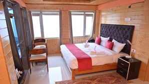 Un dormitorio con una cama grande, cabecera de madera, una mesita de noche y una silla.