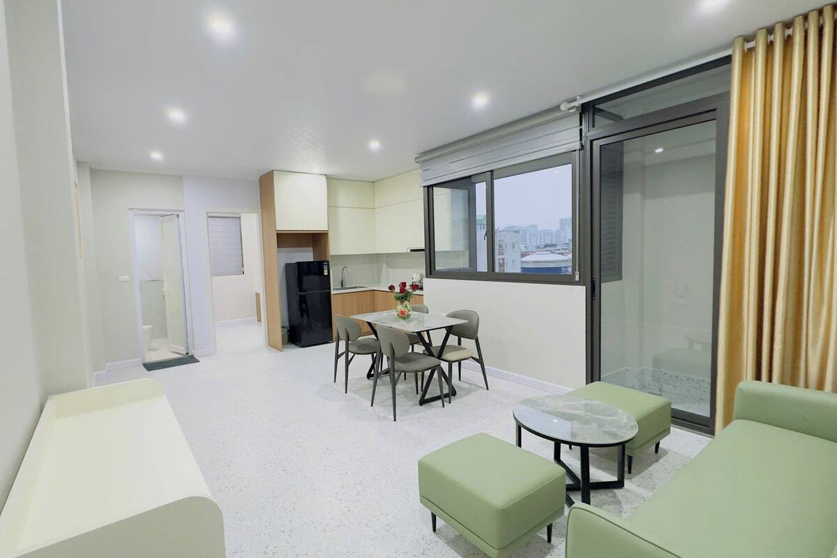 Un apartamento moderno con cocina, comedor y balcón con vista a la ciudad.