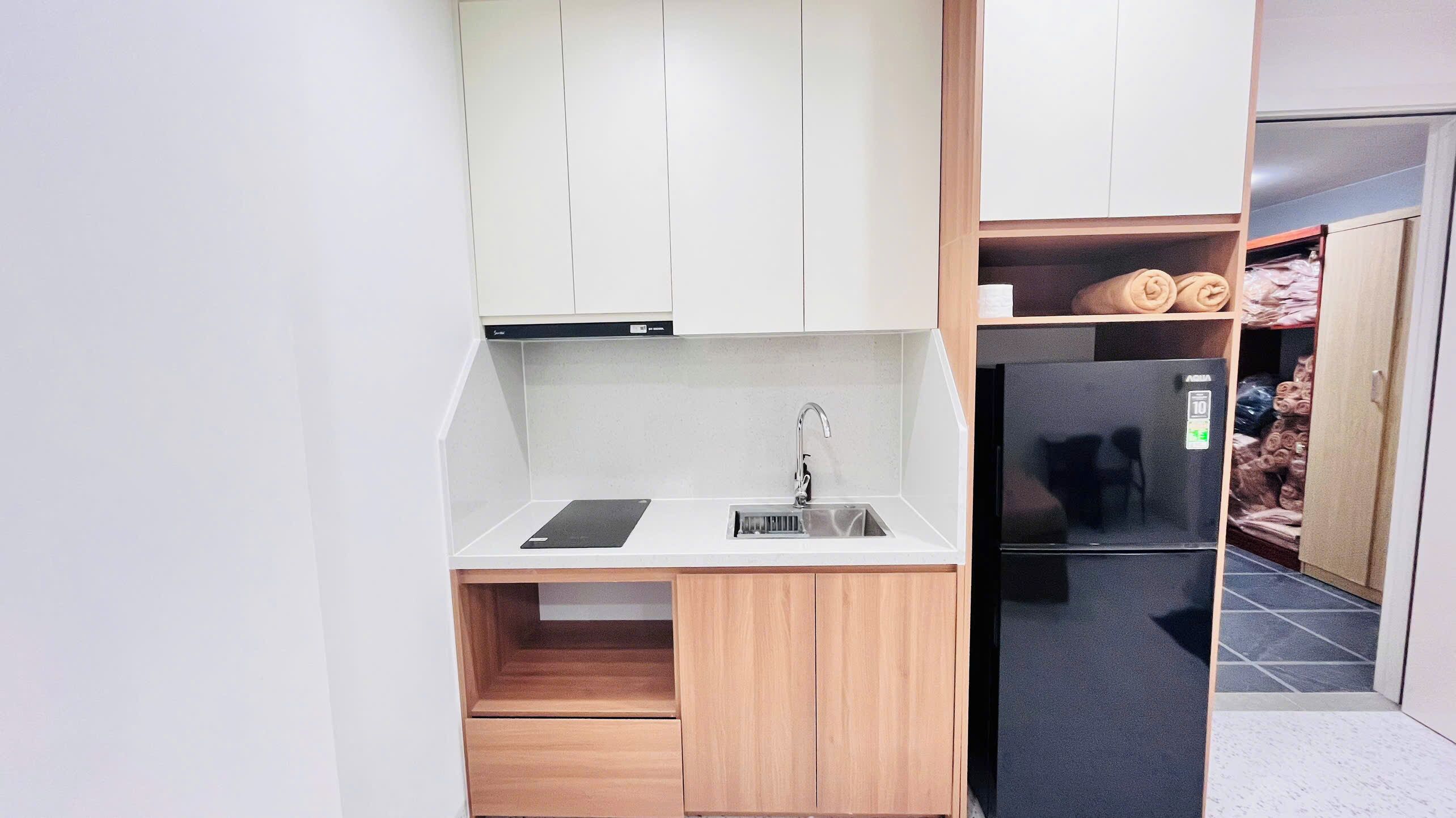 Una cocina compacta con fregadero, lavavajillas y refrigerador.