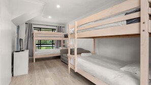 Quarto com beliche, escrivaninha e janela.