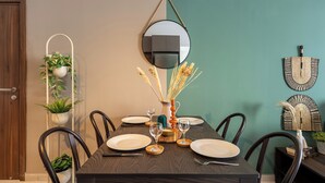 A dining table set with plates, glasses, and a vase with dried plants. - Hazel 2-BR Apt. & Balcony in Larnaca (Larnaca)