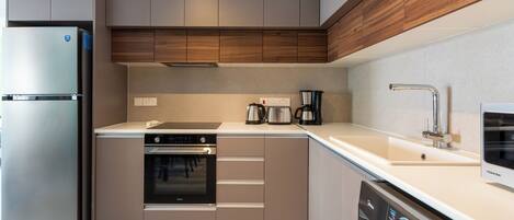 A modern kitchen with stainless steel appliances, wooden cabinets, and a built-in dishwasher.