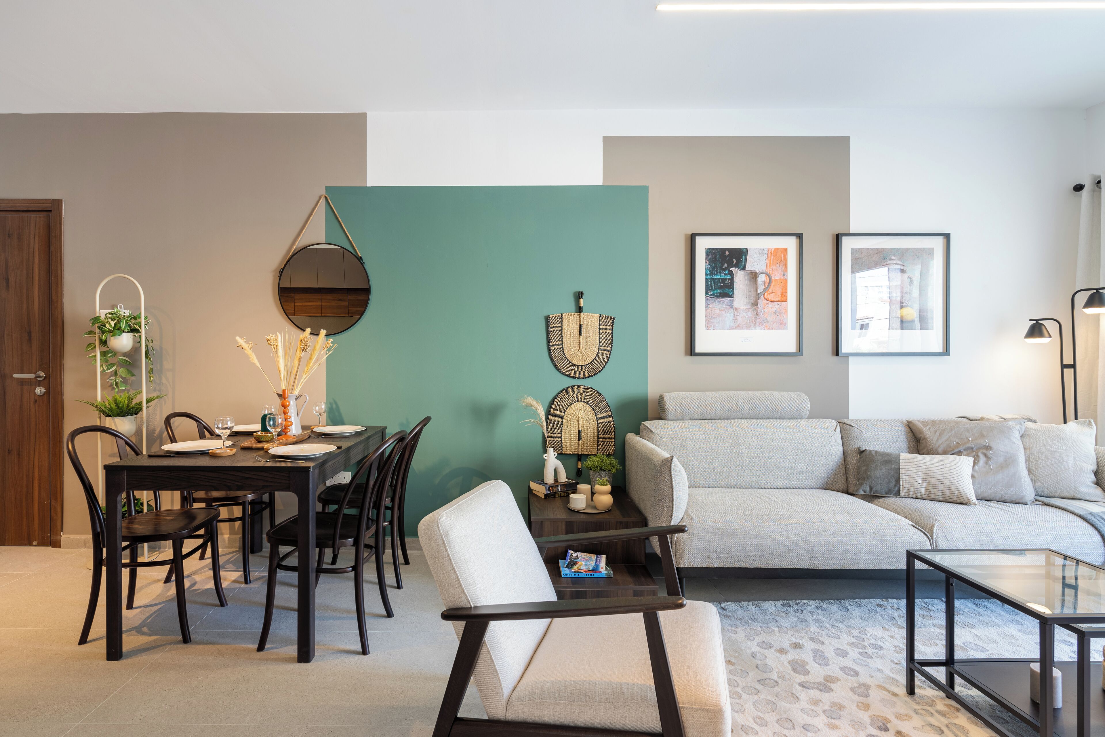 Un salon moderne comprenant un coin repas, un ensemble de canapés et une table basse.