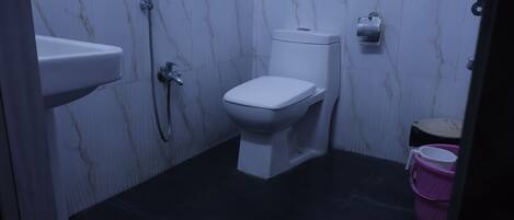 A bathroom with a toilet, a sink, and a shower.