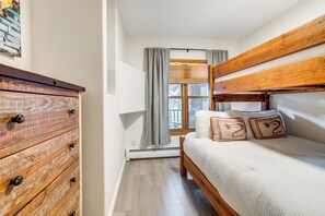 A bedroom with a bunk bed, wooden dresser, and a window with curtains. - Walk to Ski Lift & Hot Tubs! Mtn-View Keystone Gem (Keystone)