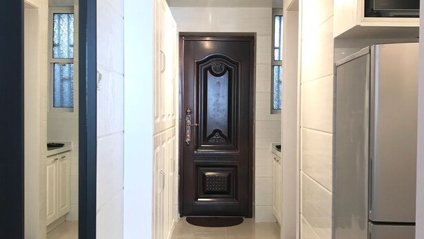 A modern kitchen with a built-in microwave, stainless steel refrigerator, and a patterned floor mat leading to a dark wooden door with decorative elements. - Innocondo Extended Stay Shanghai Changning Road (Shanghai)