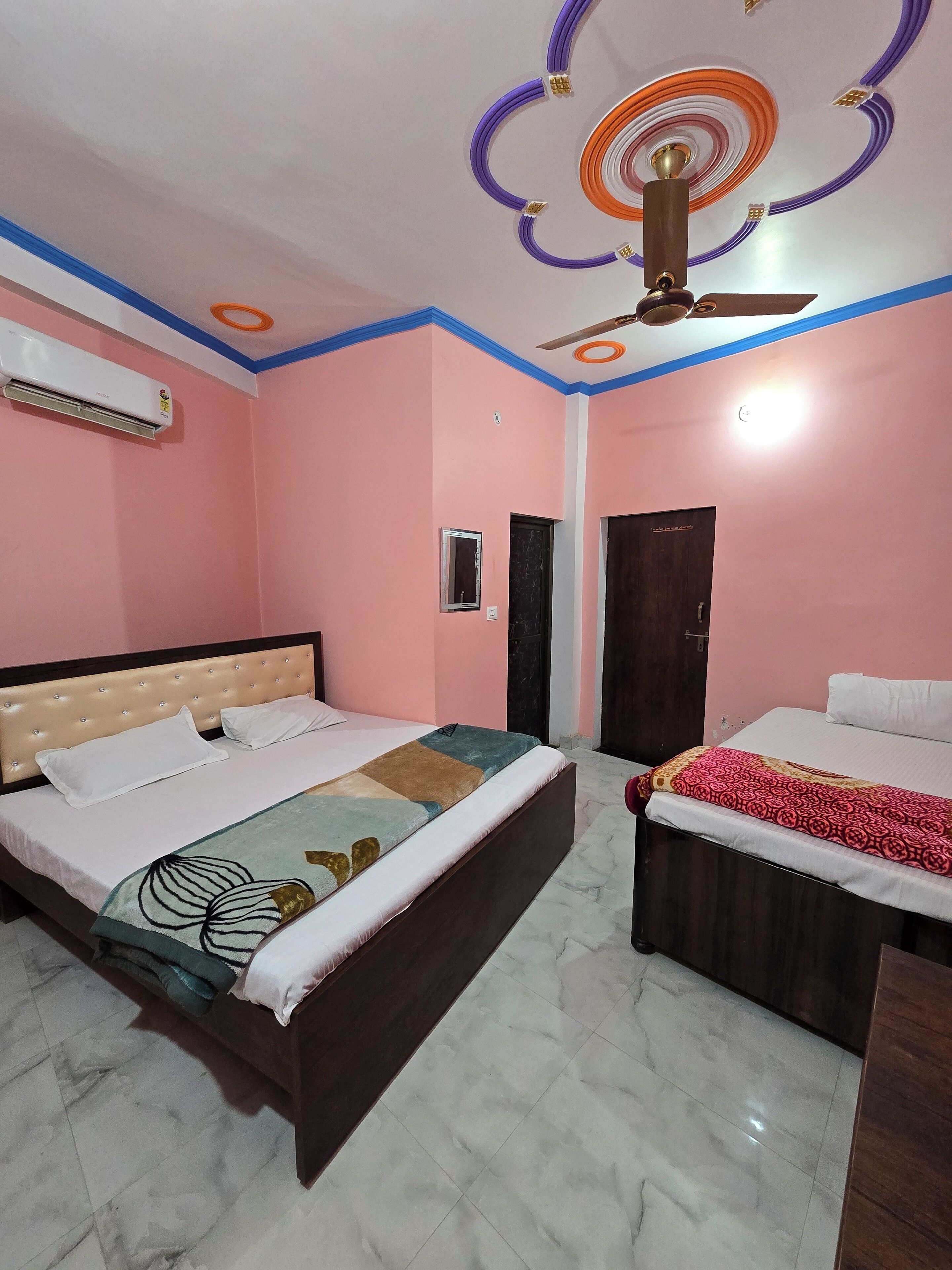 A bedroom with two beds, an air conditioner, a ceiling fan, and a decorative ceiling design.