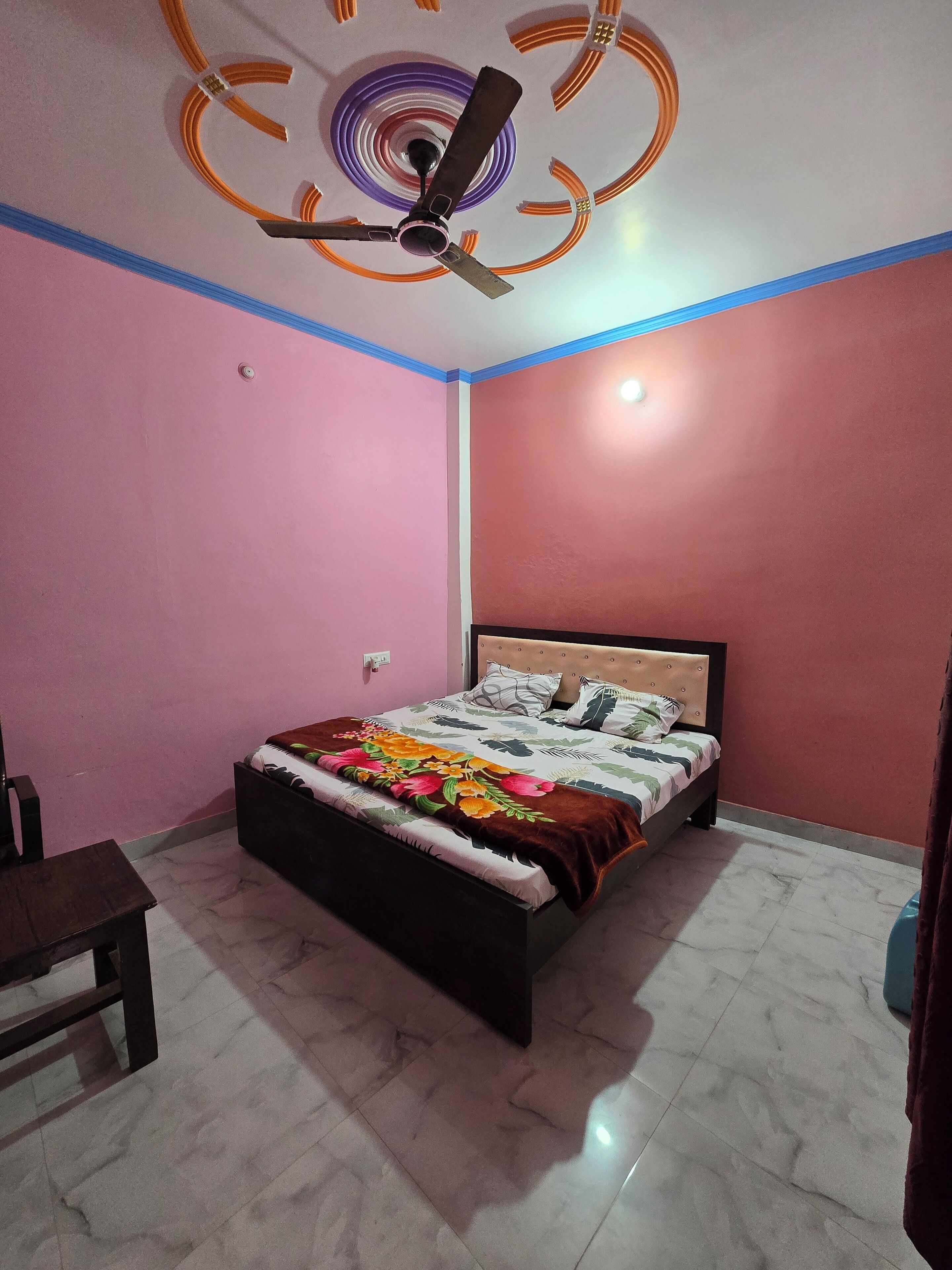 A bedroom with a bed, a ceiling fan, and a marble-tiled floor.