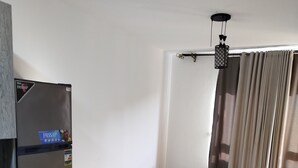 A compact kitchen with a refrigerator, a small table, and a rug. - Spacious 3-bedroom apartment in phenomenal Alexandria Governorate with AC (Alexandria Governorate)