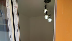 A bedroom with a single bed, a pillow, a bedside table, and a hanging light fixture. - Spacious 3-bedroom apartment in phenomenal Alexandria Governorate with AC (Alexandria Governorate)