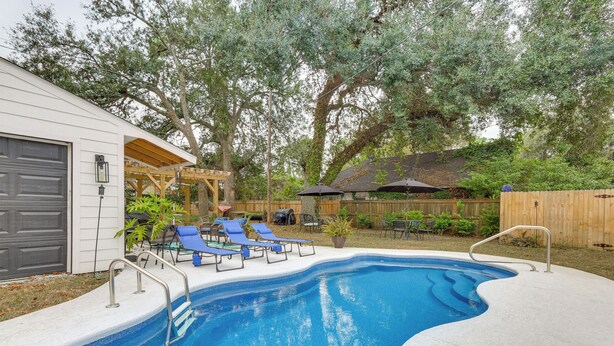 A backyard with a swimming pool, lounge chairs, and a wooden deck. - Sand Volleyball Court, Pool, Hot Tub! Fun Retreat (Savannah)