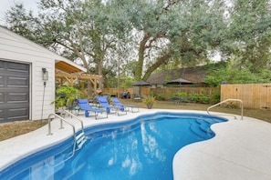 A backyard with a swimming pool, lounge chairs, and a wooden deck. - Sand Volleyball Court, Pool, Hot Tub! Fun Retreat (Savannah)