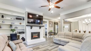 Una sala de estar moderna con chimenea, sofás y televisor.