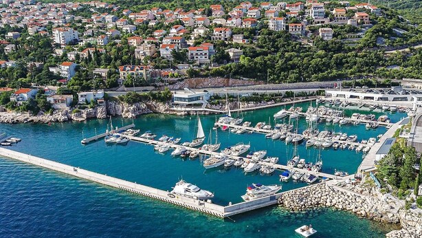 A marina with numerous boats docked, surrounded by residential buildings and greenery. - Apartman Vesna beachfront by Villas Guide (Novi Vinodolski)