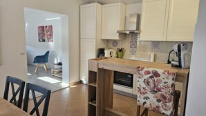A modern kitchen with white cabinets, a wooden countertop, and a coffee machine. - Apartman Damir 1 by Villas Guide (Galižana)